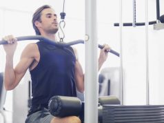 Fitness types of equipment available online Handsome man exercise with dumbbell in the gym