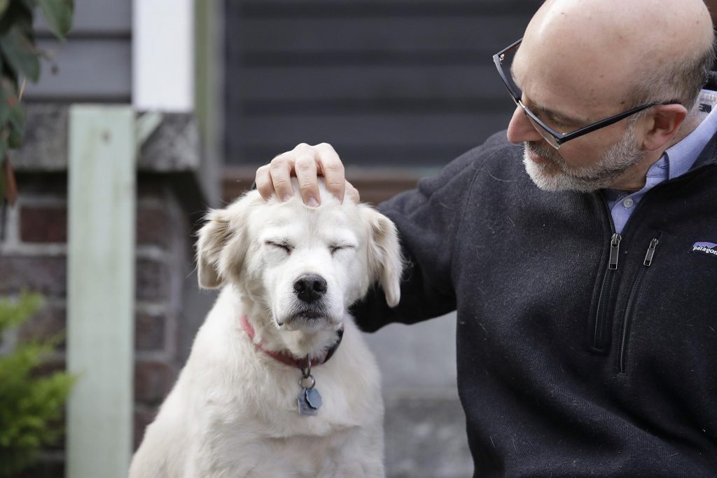 A man and a dog sitting in front of a building