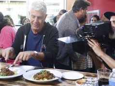 Discovering Paraguay on “Anthony Bourdain: Parts Unknown” Anthony Bourdain et al. sitting at a table with a plate of food