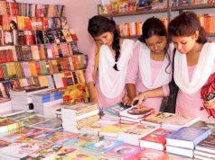 The Book Fair A girl sitting at a table looking at a book shelf