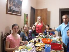 Paraguayan Birthdays: Time to Sing! A group of people sitting at a table with food