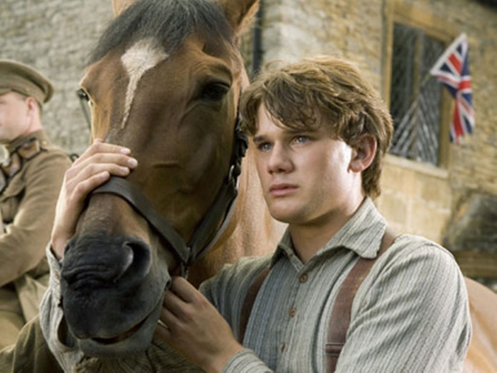 Jeremy Irvine petting a horse